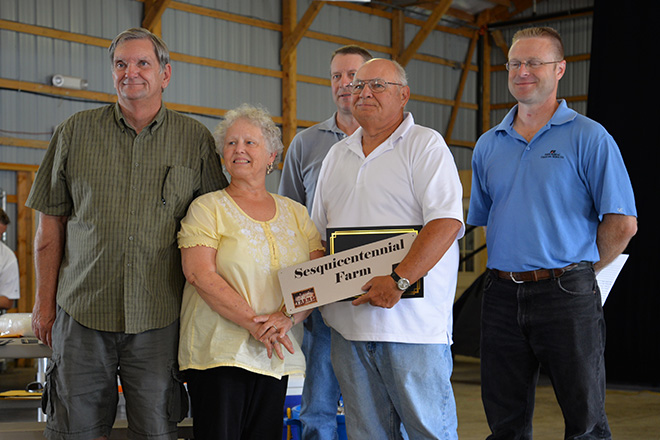 a family poses with their plaque honoring their Carver County Sesquicentennial farm