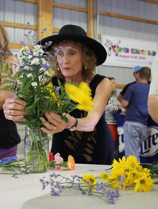 a woman arranges flowers during the flower arranging contest