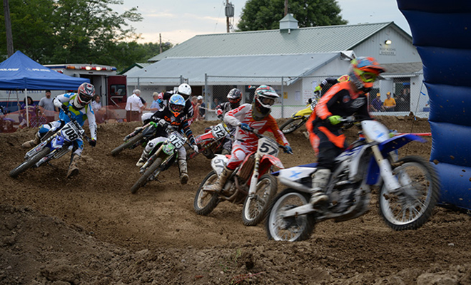 motorcross racers fight over position as they round the corner at the Carver County Fair motokazie races