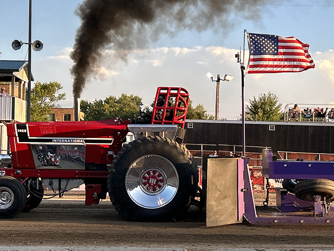red tractor billowing smoke in the NTPA Tractor Pull at the Carver County Fair