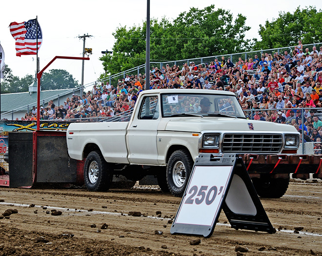 a white pick-up truck pulling a sled at the Carver County Fair Out-of-field Truck Pull