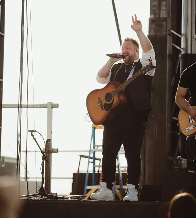 Jake Nelson waves at the crowd from up on stage