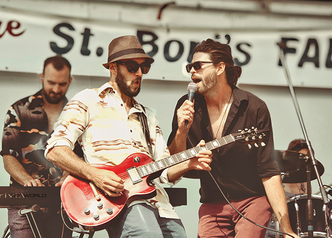 members of the band Sawyers Dream singing and playing guitar on stage
